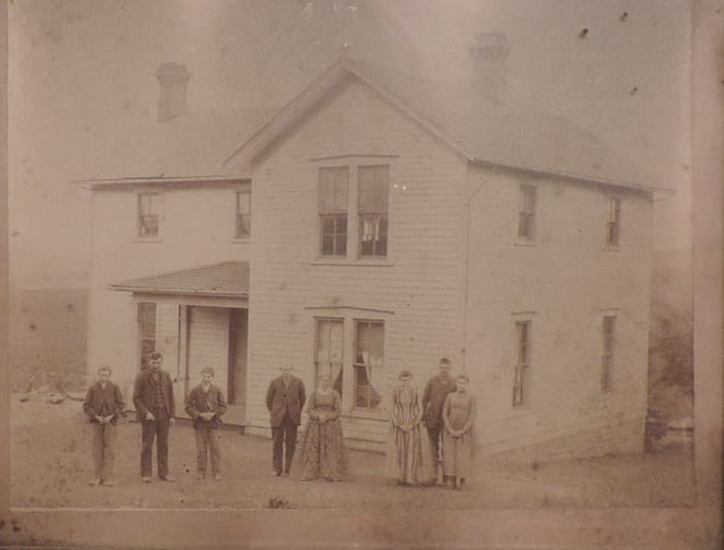 The Cummings home in Lecompton and family. Left to Right: Tom, Jim, John, Pat, Bridget, Mary, Bill, Nora.